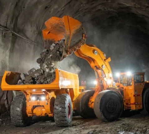 Underground loader filling an articulated dump truck.