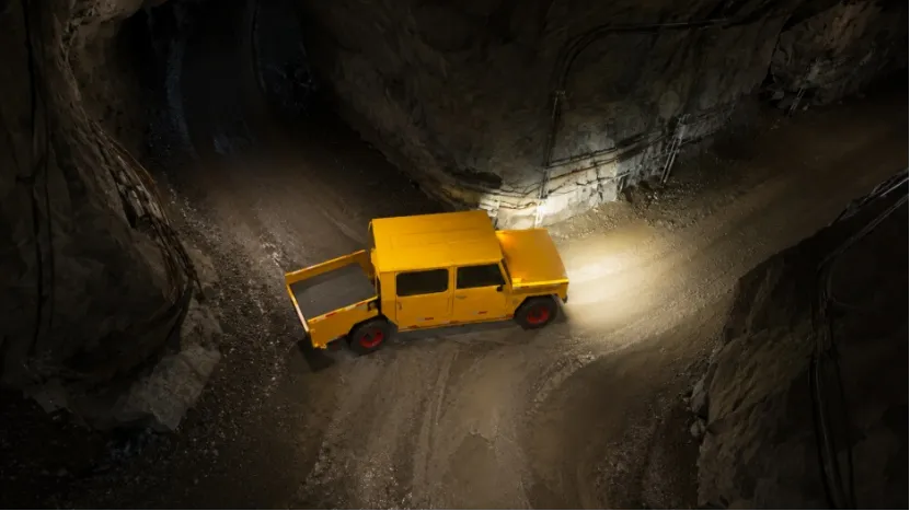 Overhead view of a yellow mining vehicle turning at a tunnel intersection
