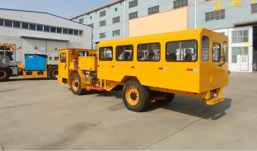 Rear-side view of a yellow articulated mining personnel carrier parked outdoors